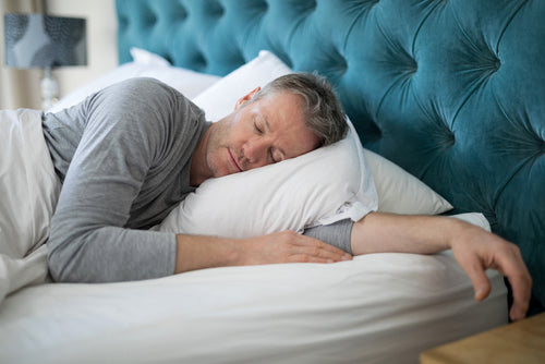 A middle-age man sleeping in bed 